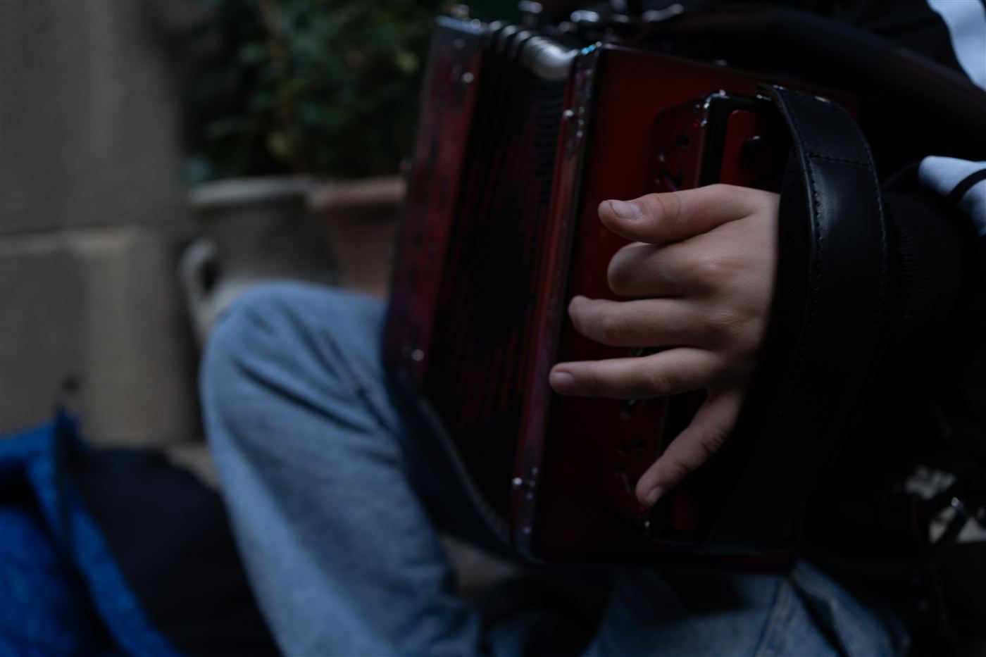 Primo piano di una mano che suona un organetto rosso